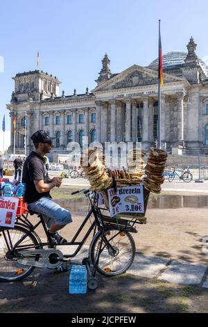 man on cycle selling pretzels, or Brezeln, in Platz der Republik near the Reichstag Building in Berlin, Germany Stock Photo