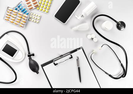 Stethoscope in the office of doctors.Top view of doctor's desk table, blank paper on clipboard with pen. Copy space. Designer's blank Stock Photo