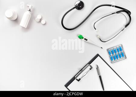 Stethoscope in the office of doctors.Top view of doctor's desk table, blank paper on clipboard with pen. Copy space. Designer's blank Stock Photo