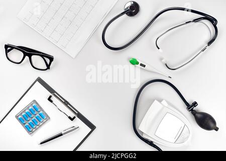 Stethoscope in the office of doctors.Top view of doctor's desk table, blank paper on clipboard with pen. Copy space. Designer's blank Stock Photo