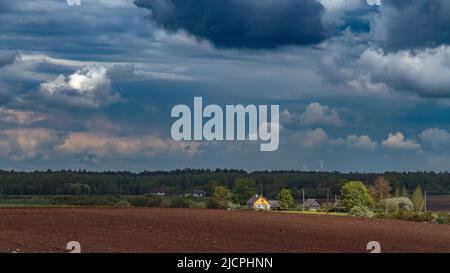 Dramatic sky with dark clouds over a field, dark clouds before rain Stock Photo
