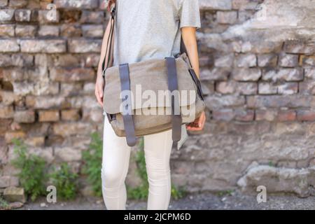 Woman with a gray canvas messenger bag. Unisex bag for sale. Stock Photo