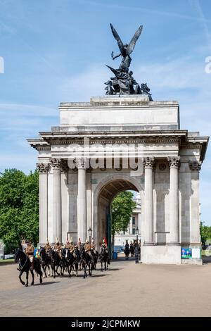 Queens Life Guards riding horses through Wellington Arch, Hyde Park Corner, London, England, United Kingdom on Wednesday, May 18, 2022. Stock Photo