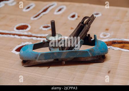 Old metallic jointer plane laying on wood table. Woodworking tools on wooden table. Carpentry workshop Stock Photo