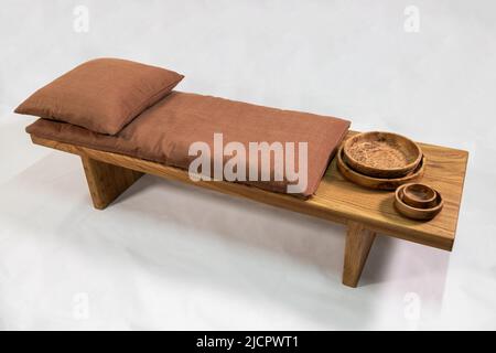 Brown wooden table with pillow and wooden bowls on a white background Stock Photo