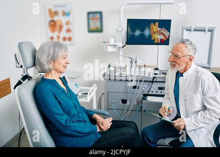 Senior woman while consultation with ENT doctor at medical clinic indoors. Treatment of ENT disease in elderly people Stock Photo