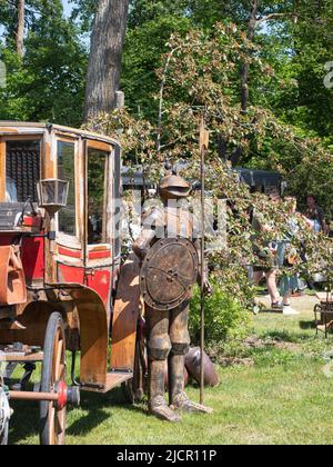 Beervelde, Belgium, 08 May 2022, Rusty knight's suit from the Middle Ages, with a lance on an old carriage Stock Photo