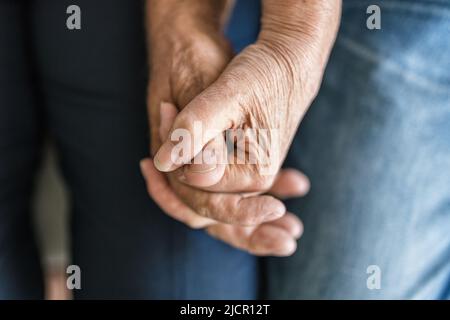 Happy romantic senior couple in love holding hands at home Stock Photo
