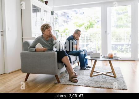 Upset senior couple at home in living room having an argument Stock Photo