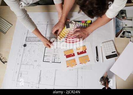 Professional architect and engineer working on big house for client, checking blueprint and choosing paint color Stock Photo