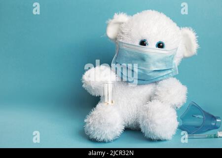big teddy bear are sitting in white medical masks on a blue background. Respiratory medicine. Stock Photo