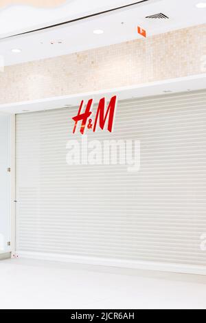 Saint Petersburg, Russia - 04.01.2022: Hennes and Mauritz or hm or H and M is closed in shopping mall of St. Petersburg. White roller shutter door or Stock Photo