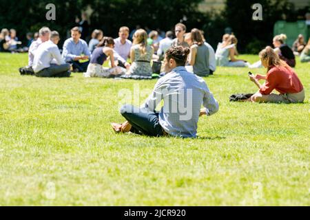 London, UK. 15th June, 2022. UK Weather, office workers take break with the summer sunshine and record temperatures in Victoria Tower Gardens, London UK office workers sunbathing, Credit: Ian Davidson/Alamy Live News Stock Photo