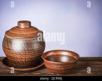 Ceramic brown pot on a saucer with an empty clay bowl Stock Photo