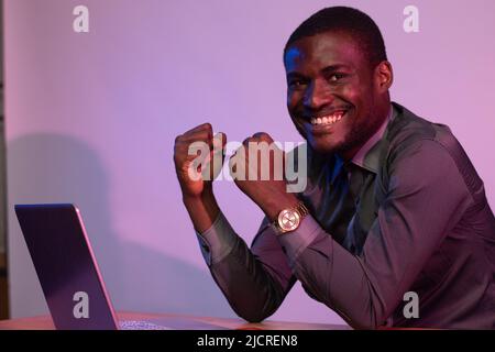 african man using his laptop rejoices Stock Photo