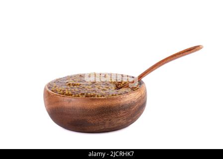Wooden spoon inside french mustard. Wooden bowl with mustard sauce made from white and black mustard seeds. Copy space. Stock Photo