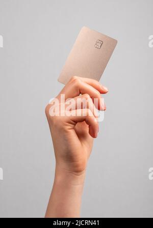 Hand holding credit card mockup with chip. Buying at stores, making transactions at terminals. Secure payments. High quality photo Stock Photo