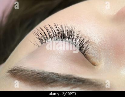 The procedure of classical eyelash extension. Eyelash extension close-up Stock Photo