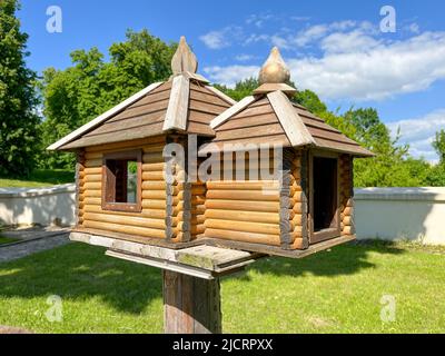 Wooden bird feeder in the form of a house with bait Stock Photo