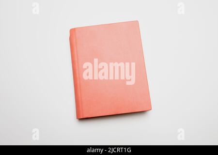 Book isolated on white background. Blank cover pink color leather hardcover diary, copy space, template Stock Photo