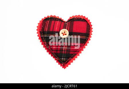 Valentine day, Love symbol, design element. Heart red black checkered cloth and button isolated on white. Textile texture heart shape decoration Stock Photo