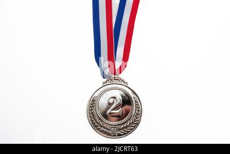 Silver medal, second place. Champion trophy award and red blue ribbon, design element. Prize in sport isolated cutout on white background Stock Photo