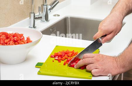 man preparing salad on cutting board beautiful view in modern kitchen Stock Photo