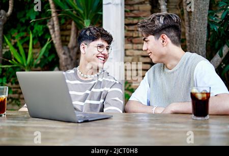 Gay Couple influencers Recording Video Of Themselves Using laptop Stock Photo