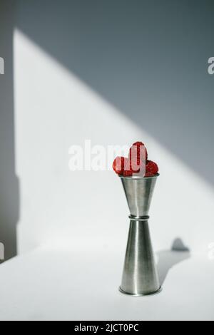 Fresh Raspberries in a Stainless Steel Jigger on a White Background Stock Photo