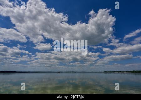 Blue sky with white clouds reflecting on the water Stock Photo - Alamy