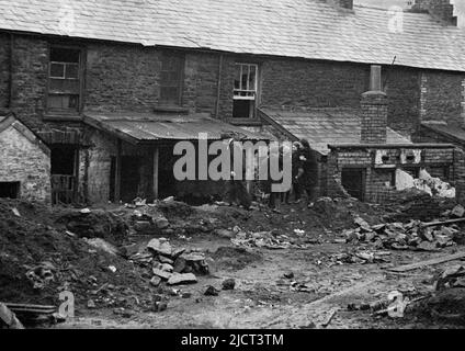 1948, historical, children playing in a damp, wet street of old stone ...