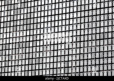 Metal rectangular plates with screws and rivets on the facade of the building decorative pattern of gray stainless steel sheets, industrial architectu Stock Photo