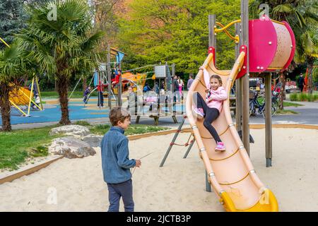 LONDON, UK - 23.04.2022: Boys and girls with the parents on the playground, weekend with family concept Stock Photo