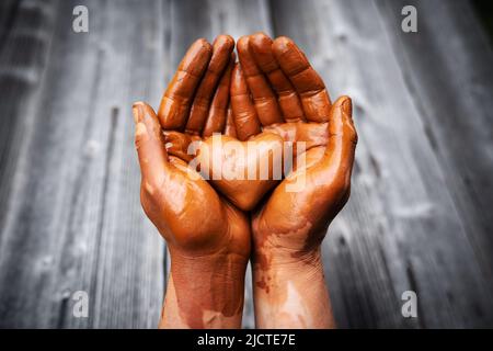 Heart made of potter's clay in the hands of a master potter. Love concept Stock Photo