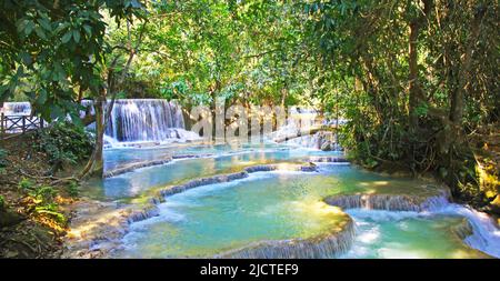 Beautiful idyllic lonely tropical waterfall staircase cascade, turquoise blue secluded water plunge pools, green forest jungle - Kuang Si, Luang Praba Stock Photo