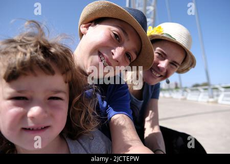 Cheerful mother and kids taking selfie together on bridge Stock Photo