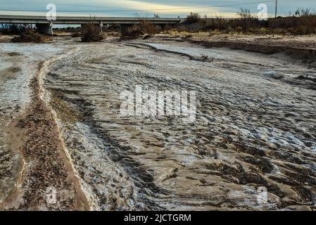 Cracked red clay and white salt on the surface in a dried riverbed in the desert of New Mexico, USA Stock Photo