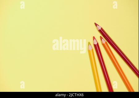yellow background with colored pencils in warm color Stock Photo