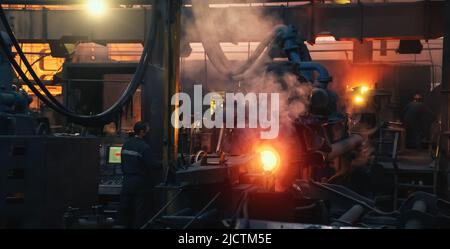 Production process of cast iron water pipes at industrial steel mill. Metallurgical foundry factory with press forming machines for manufacturing tubing. Heavy industry interior background. Stock Photo