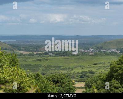 Long distance view of the castle in Corfe Castle from Kingston, Purbeck, Dorset, UK. Stock Photo