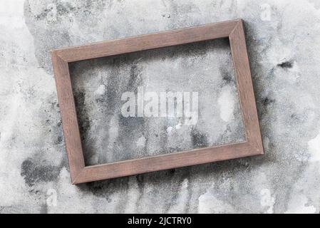Wooden photo frame on background of gray painted wall, copy space Stock Photo
