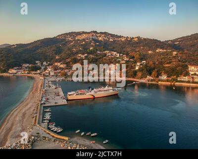 The picturesque port of Glossa village in Skopelos island, Sporades, Greece. Scenic view of a Ferry boat docking in a small beautiful Greek harbor at Stock Photo