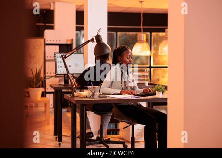 Company employee analyzing research data on computer at office job, working with executive information to create email report for manager. Looking at management paperwork on pc. Stock Photo
