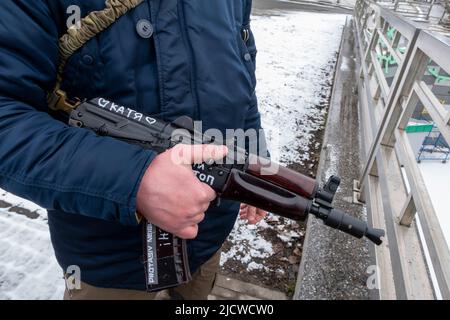 KYIV, UKRAINE 01 March. A member of the Territorial defense forces stands guard with a Kalashnikov rifle bearing writing with the name of his girlfriend 'Katia' in Protasiv neighbourhood as Russia's invasion of Ukraine continues on 01 March 2022 in Kiev, Ukraine. World War II. Stock Photo