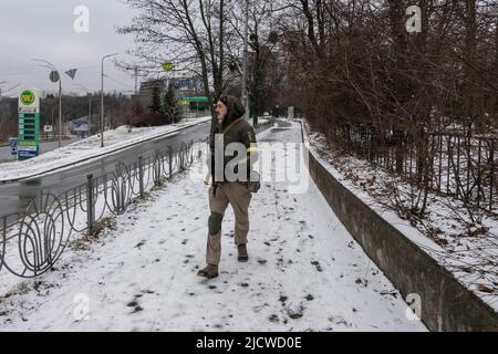 KYIV, UKRAINE 01 March. A member of Kyiv's civil defense walks with a Kalashnikov rifle in his neighborhood as Russia's invasion of Ukraine continues on 01 March 2022 in Kiev, Ukraine. Stock Photo