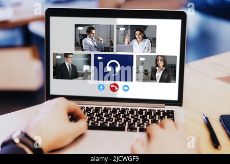 Laptop screen with different business partners, colleagues and man hands on keyboard, online video communication and group remote work concept Stock Photo