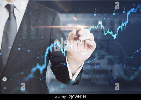 Business investment and stock market analyzing concept with businessman in black suit touching virtual interface with financial chart diagram and grap Stock Photo