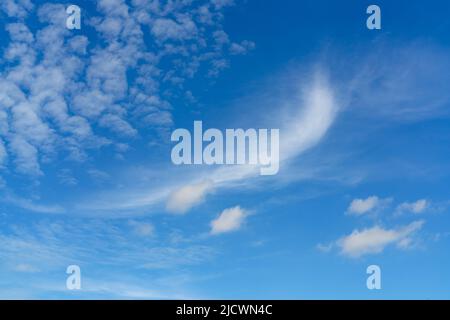Beautiful blue summer sky and white cirrocumulus clouds background. Cloudscape background. Blue sky and fluffy white clouds on a sunny day. Nice Stock Photo
