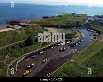 Boats at low tide at Seaton Sluice harbour in Northumberland, on what is forecast to be the hottest day of the year so far. Picture date: Thursday June 16, 2022. Stock Photo