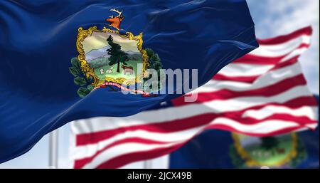 The Vermont state flag waving along with the national flag of the United States of America. Vermont is a state in the New England region of the United Stock Photo